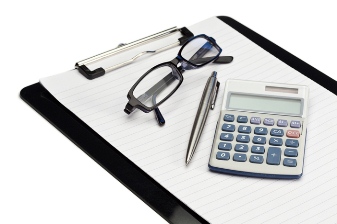 Angled note pad, pen, glasses and pocket calculator